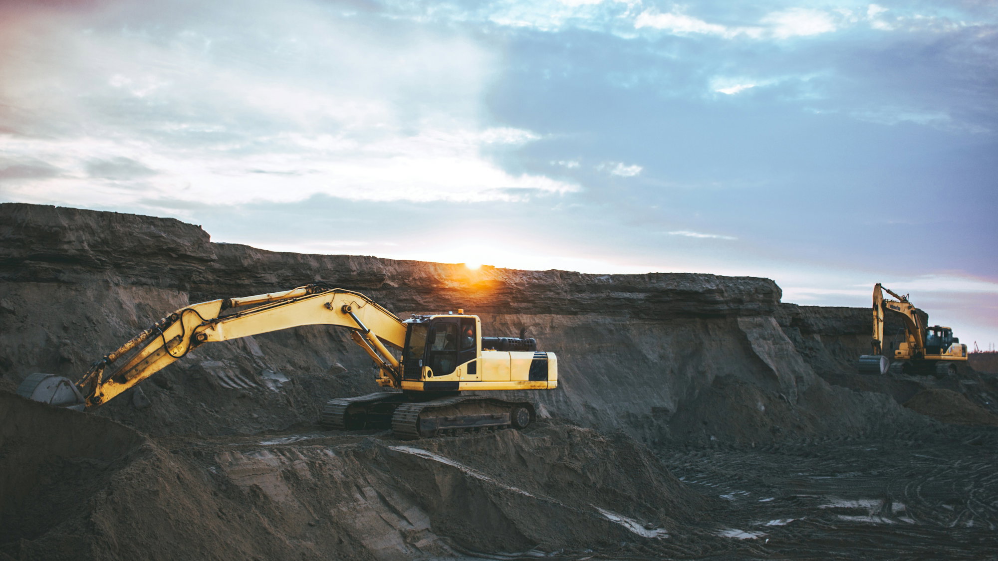 yellow-and-white-excavator-on-rocky-mountain-during-daytime.jpg yellow and white excavator on rocky mountain during daytime