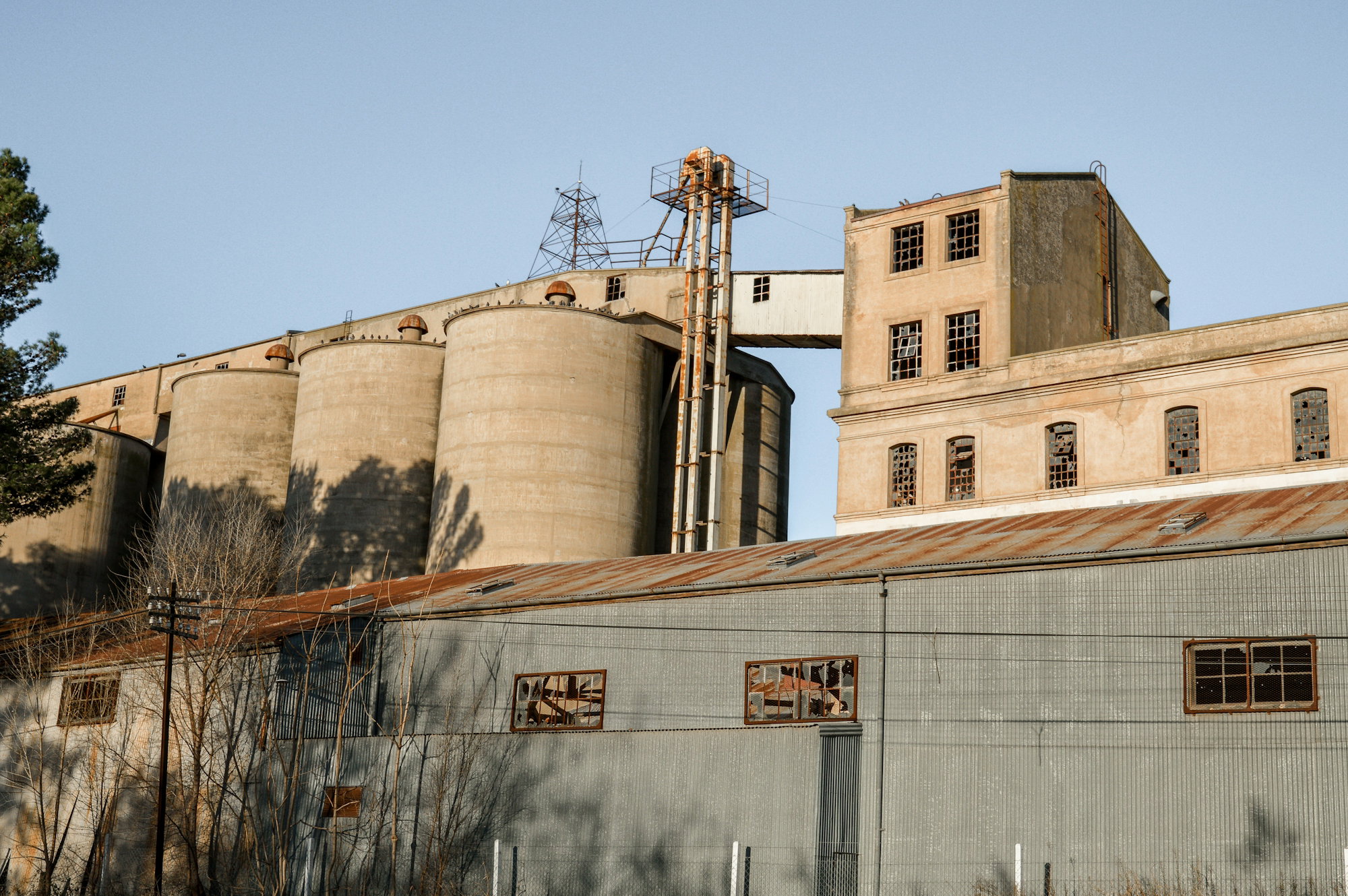 an old factory building with a water tower in the background